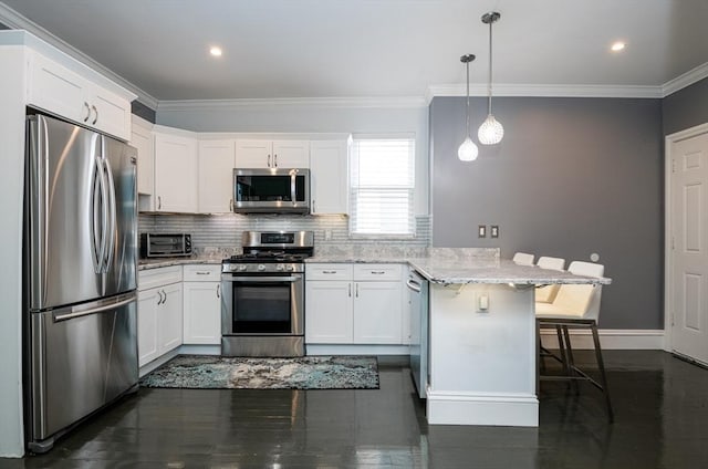 kitchen featuring appliances with stainless steel finishes, light stone counters, white cabinetry, pendant lighting, and a breakfast bar area