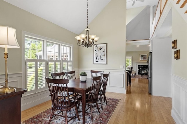 22 Hummock Way Unit 22, Hudson, MA 01749 - dining space with a decorative wall, wainscoting, light wood-style floors, a chandelier, and high vaulted ceiling