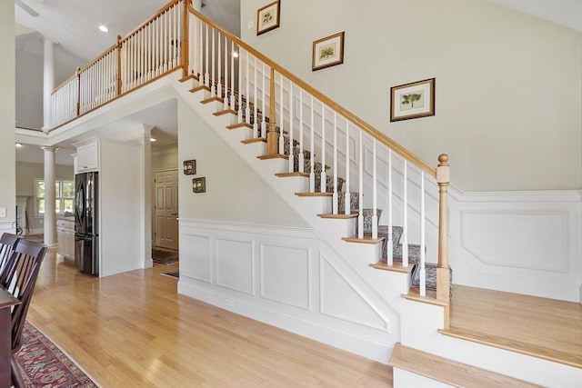22 Hummock Way Unit 22, Hudson, MA 01749 - stairs with ornate columns, a high ceiling, wood finished floors, a decorative wall, and wainscoting