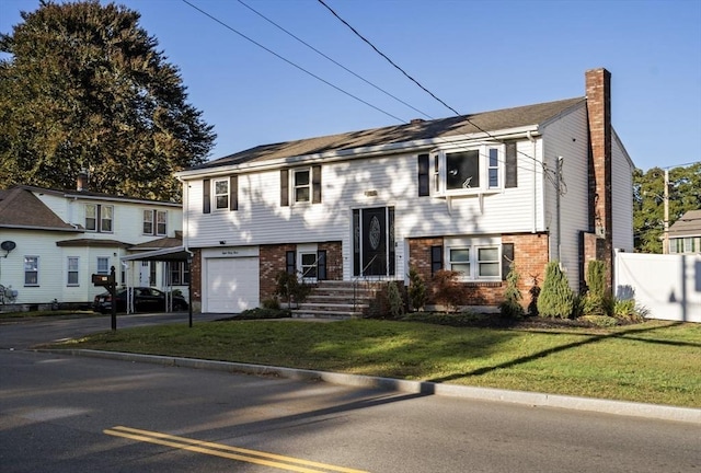 bi-level home featuring a garage and a front yard