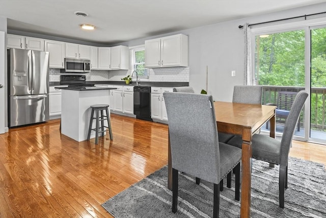 60 Mahogany Run Unit 60, Leominster, MA 01453 - kitchen with black appliances, white cabinets, decorative backsplash, and light wood finished floors