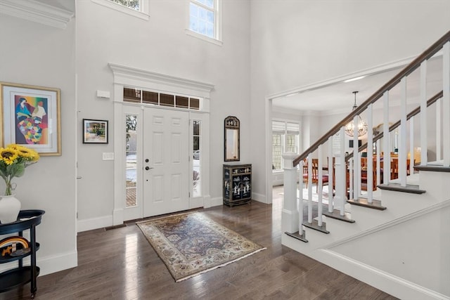 foyer featuring dark wood-style floors, stairway, a chandelier, and a wealth of natural light