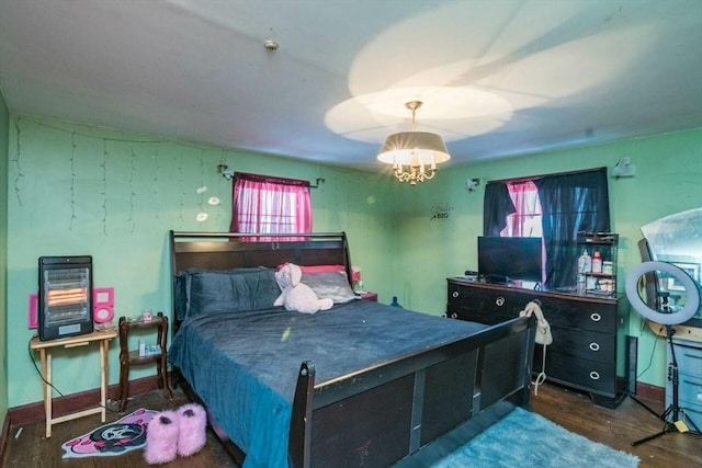 bedroom featuring baseboards, dark wood-type flooring, and a notable chandelier