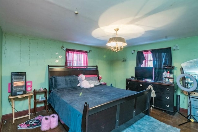 bedroom with dark wood finished floors, a notable chandelier, and baseboards