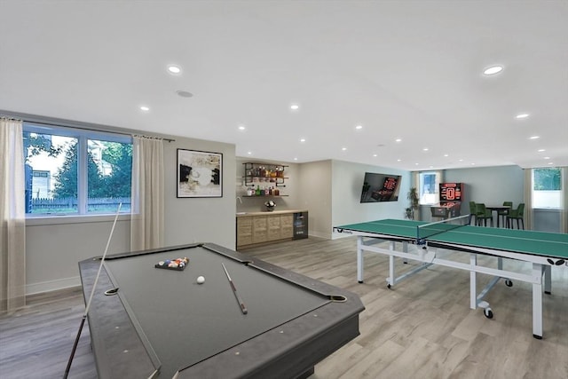 playroom with bar, billiards, and light wood-type flooring