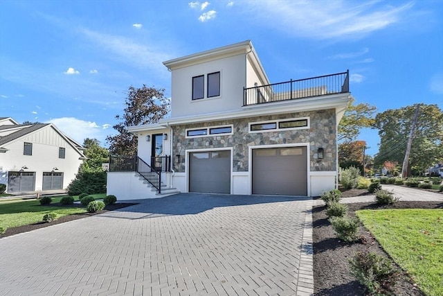 view of front of house featuring a garage and a balcony