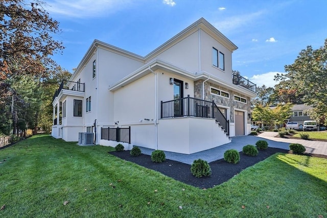 view of home's exterior featuring a balcony, a garage, and a yard