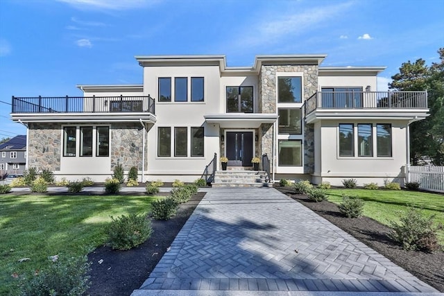 view of front facade with a front lawn and a balcony