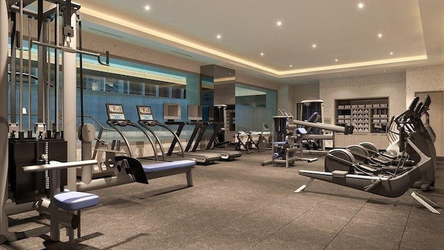 workout area with a tray ceiling