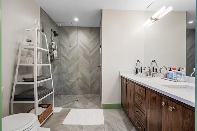 bathroom featuring a tile shower, tile patterned floors, vanity, and toilet