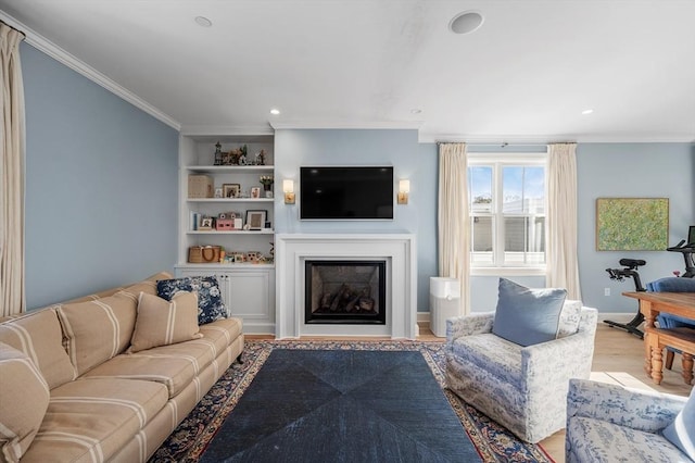 living room with built in shelves, crown molding, and light hardwood / wood-style floors