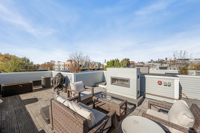 view of patio featuring an outdoor living space with a fireplace, central AC unit, and a wooden deck