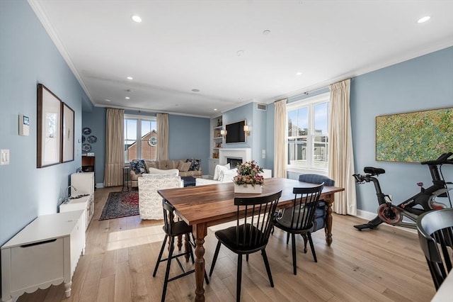 dining space featuring light hardwood / wood-style flooring, a wealth of natural light, and ornamental molding