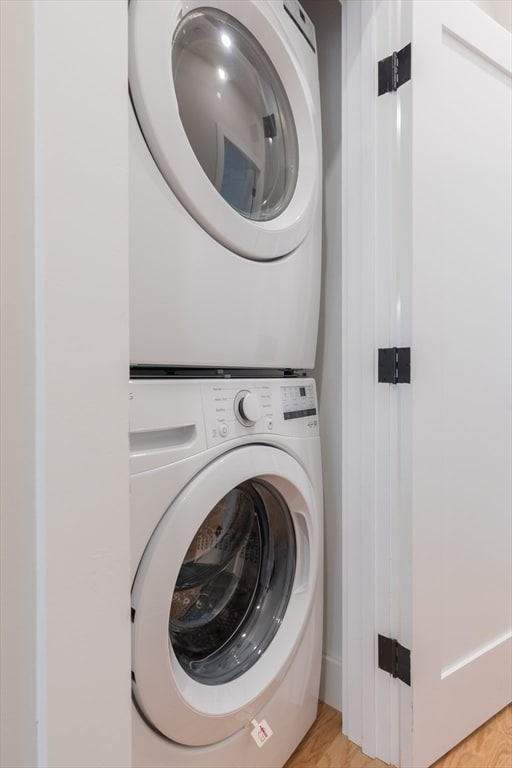 washroom featuring light wood-type flooring and stacked washing maching and dryer