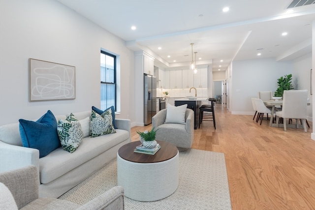 living room featuring light hardwood / wood-style flooring and sink