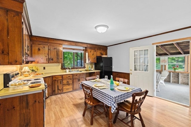 225 Pleasant St, Weymouth, MA 02190 - kitchen featuring freestanding refrigerator, brown cabinets, wooden walls, ornamental molding, and light countertops