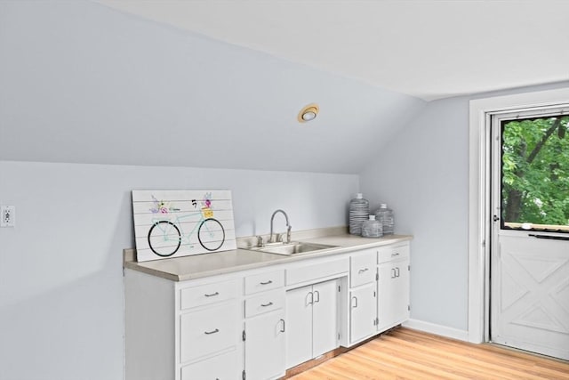 225 Pleasant St, Weymouth, MA 02190 - kitchen with a sink, vaulted ceiling, white cabinetry, light wood-type flooring, and light countertops