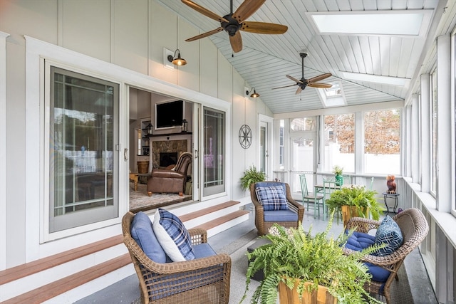 sunroom / solarium featuring vaulted ceiling with skylight and ceiling fan