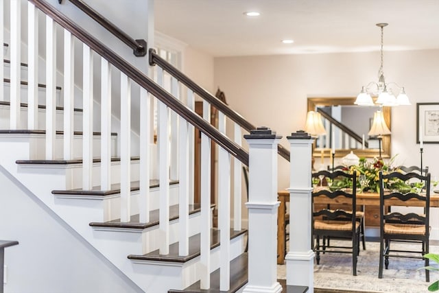 stairs with a notable chandelier