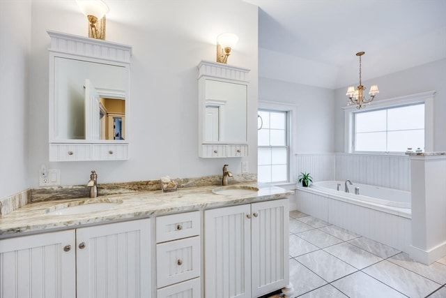 bathroom featuring tile patterned floors, vanity, a relaxing tiled tub, and an inviting chandelier