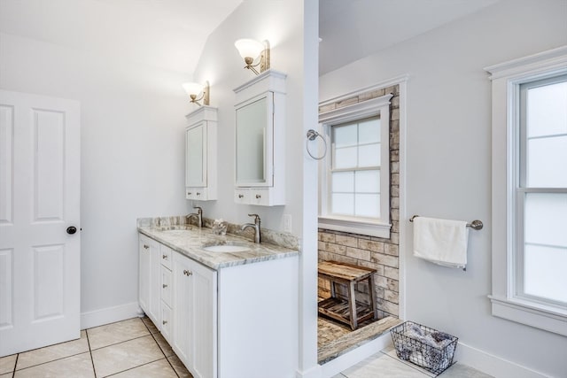 bathroom featuring tile patterned flooring, vanity, and vaulted ceiling