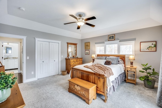 carpeted bedroom featuring connected bathroom, ceiling fan, and a closet