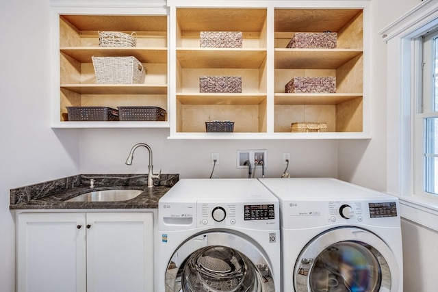 laundry area with washer and dryer, cabinets, and sink