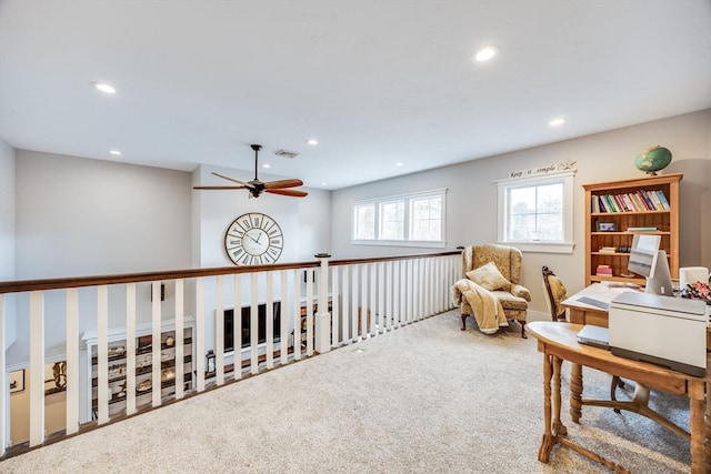 living area featuring carpet floors and ceiling fan