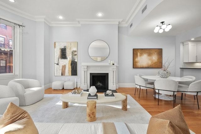 living room with light wood-type flooring and ornamental molding