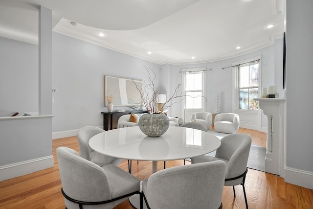 dining space with light wood-type flooring and crown molding