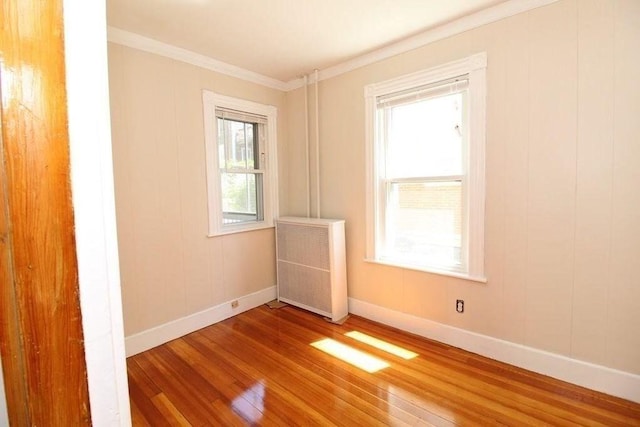 spare room with radiator, crown molding, and hardwood / wood-style flooring