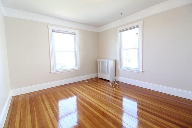 empty room with radiator heating unit and hardwood / wood-style floors