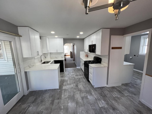 kitchen featuring black appliances, backsplash, sink, and white cabinetry