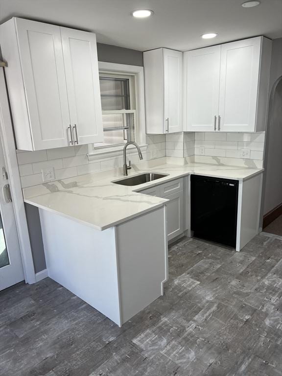 kitchen with kitchen peninsula, dishwasher, white cabinets, and sink