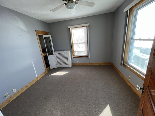 interior space with ceiling fan and radiator heating unit