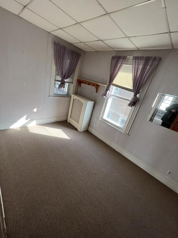 carpeted empty room featuring radiator