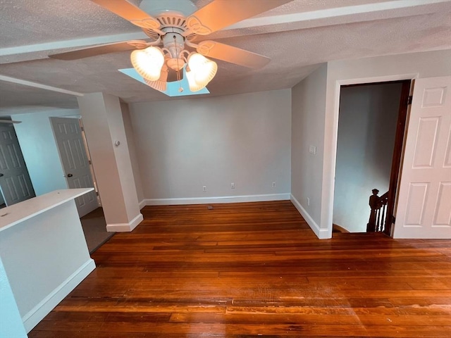 unfurnished room featuring a textured ceiling, ceiling fan, and dark wood-type flooring