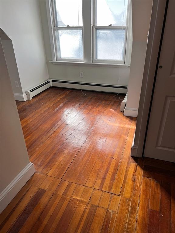 spare room featuring plenty of natural light and wood-type flooring