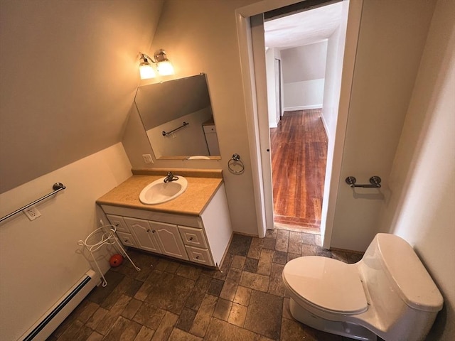 bathroom with toilet, vanity, and baseboard heating