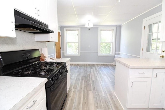 kitchen featuring light hardwood / wood-style floors, decorative backsplash, black gas stove, a paneled ceiling, and white cabinets