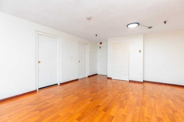 empty room featuring baseboards and light wood-style floors