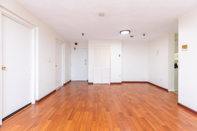 empty room with light wood finished floors and baseboards