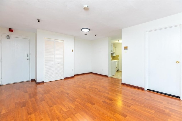 unfurnished room featuring light wood-type flooring and baseboards