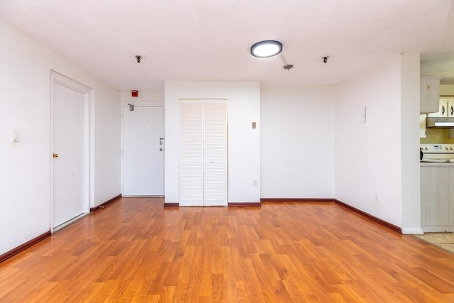 empty room with light wood-style floors and baseboards