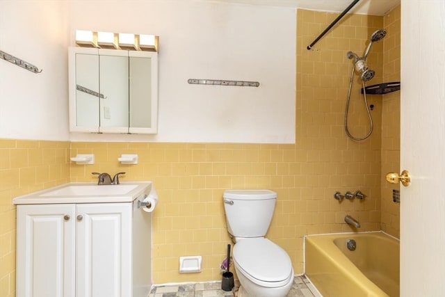 full bath featuring shower / bathtub combination, toilet, a wainscoted wall, vanity, and tile walls