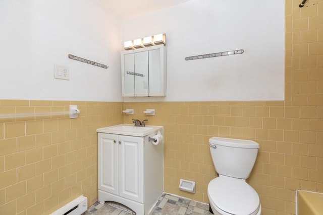 full bath with a wainscoted wall, toilet, vanity, and tile walls