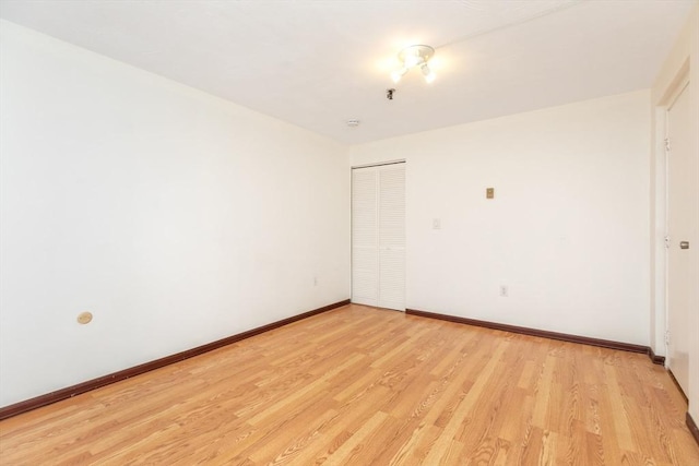 spare room with light wood-type flooring and baseboards