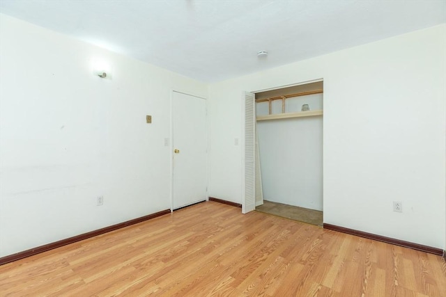 unfurnished room with baseboards and wood finished floors