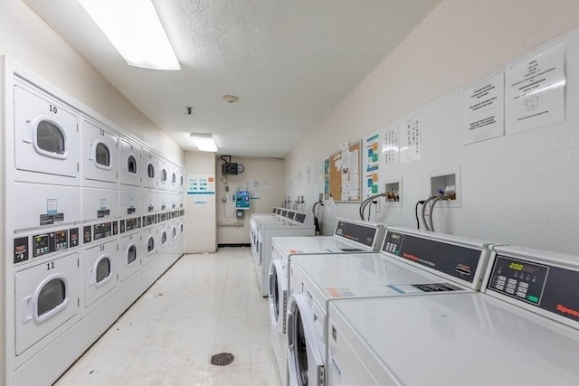 community laundry room with a textured ceiling, stacked washer / drying machine, and washing machine and clothes dryer