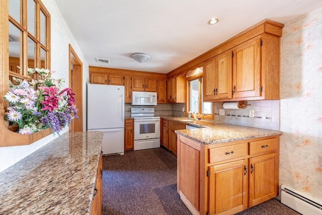 kitchen featuring visible vents, white appliances, light stone countertops, baseboard heating, and a sink